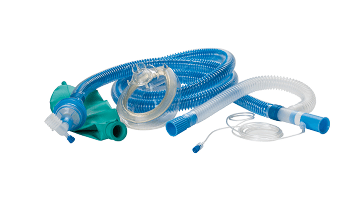 Medisinsk pusteslange og gassmaske med gjennomsiktig og blått utstyr på hvit bakgrunn.