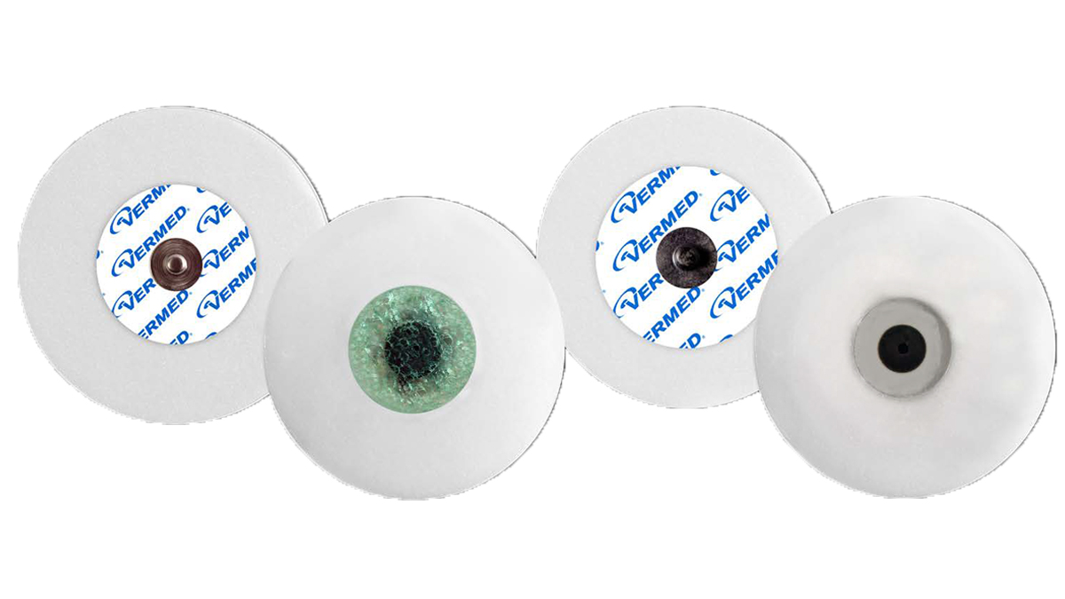 Fire runde EKG-elektroder med forskjellige farger og merking, brukt til overvåkning av hjerteaktivitet.