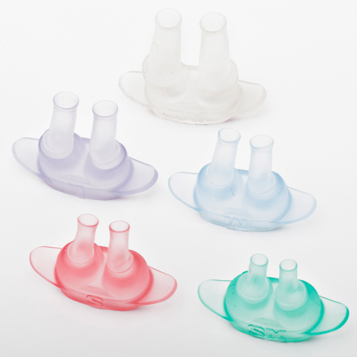 Fem färgglada silikonspetsar för näskanyl arrangerade på en vit bakgrund.