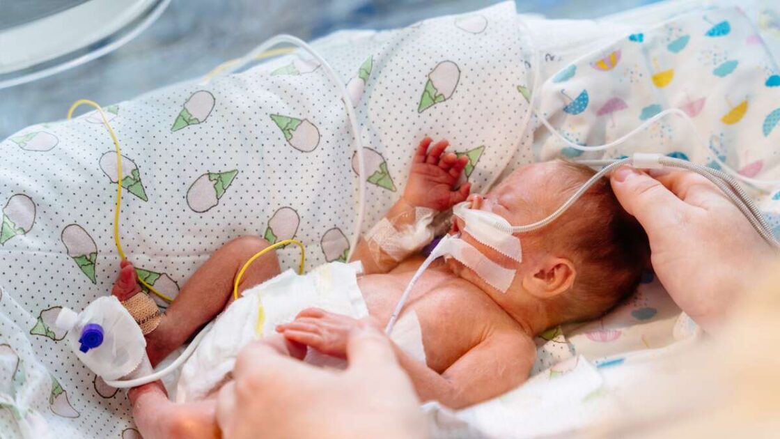 For tidlig født baby i inkubator som sover og får stell